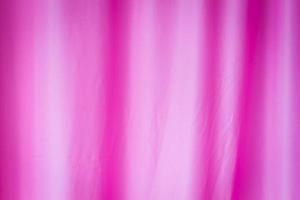 roze verfrommeld textielgordijn met plooien voor achtergrond. foto