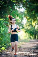 jonge fitness vrouw draait op een landelijke weg. sport vrouw lopen. foto