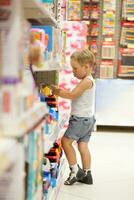 jongen aan het kijken auto's in de speelgoed- winkel foto