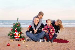 Kerstmis portret van gelukkig familie Aan de strand foto