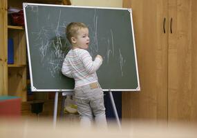 creatief weinig jongen tekening Aan een schoolbord foto