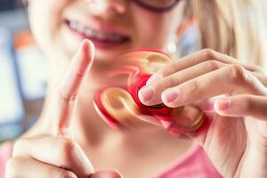 friemelen spinner. schattig jong meisje spelen met friemelen spinner. foto