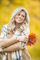 herfst portret van jong vrouw met boeket van esdoorn- bladeren foto