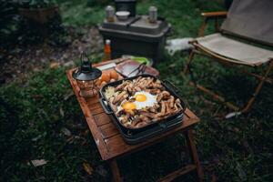 gebakken eieren en gegrild varkensvlees in een camping pan foto