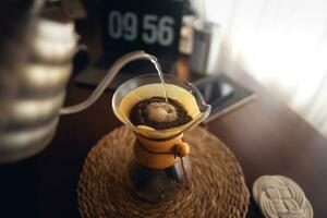 druppelen koffie, gieten water in filter koffie maker foto