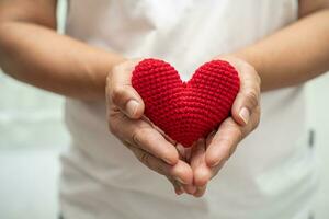 Aziatisch vrouw vrijwilliger Holding een rood hart, bijdrage, liefdadigheid, vertrouwen, verzekering concept. foto