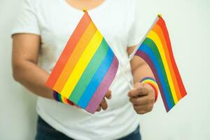 vrouw Holding lgbt regenboog kleurrijk vlag, symbool van lesbienne, homo, biseksueel, transgender, menselijk rechten, tolerantie en vrede. foto