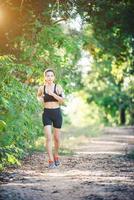 jonge fitness vrouw draait op een landelijke weg. sport vrouw lopen. foto