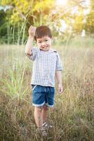 gelukkige kleine Aziatische jongen die buiten speelt. schattige Aziatische jongen op veld. foto