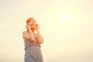 mooie sexy vrouw luisteren muziek van smartphone in de bloem. foto