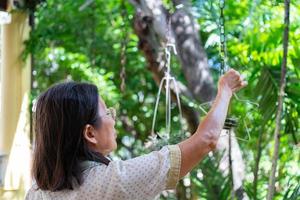senior aziatische vrouw hangende luchtplant versier verticale tuin foto
