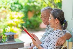 senior aziatisch paar dat tablet samen thuis gebruikt foto