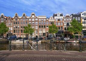 typisch gebouwen, kanaal en Fietsen in Amsterdam, Nederland foto