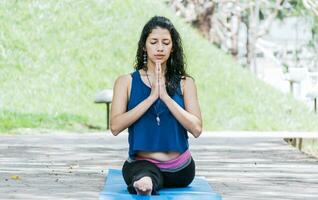 meisje zittend aan het doen spleet meditatie yoga buitenshuis, vrouw aan het doen kant spleet yoga buitenshuis, jong vrouw aan het doen kant spleet yoga foto