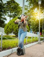 vrouw spelen viool in de straat. portret van violist meisje spelen in de straat. vrouw artiest spelen viool buitenshuis, meisje aan het liegen naar beneden spelen viool in een park foto