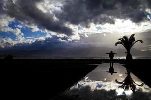uitzicht op zee en een silhouet van een man op het water foto