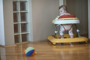 baby aan het leren naar wandelen in wandelaar foto