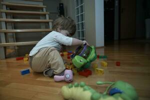 aanbiddelijk schattig mooi weinig baby meisje spelen met speelgoed Bij huis foto