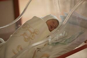 pasgeboren baby slapen in bed Bij ziekenhuis foto