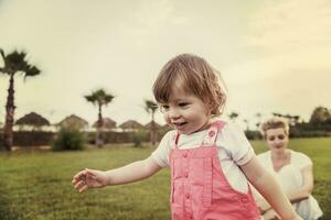 moeder en weinig dochter spelen Bij achtertuin foto