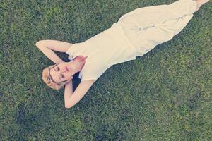 top visie van jong vrouw ontspannende Aan de gras foto