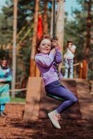 een weinig meisje spelen in de park. de concept van familie gezelligheid in de park. een meisje schommels Aan een schommel, Toneelstukken creatief spellen foto