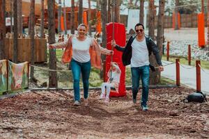 familie pret in de park. gelukkig familie uitgeven tijd in park en spelen met hun dochter foto