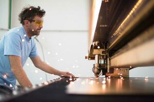 binnen zwaar industrie. een Mens werken in een modern fabriek Aan een cnc machine. selectief focus foto