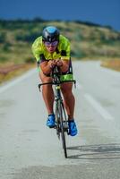 vol lengte portret van een actief triatleet in sportkleding en met een beschermend helm rijden een fiets. selectief focus foto