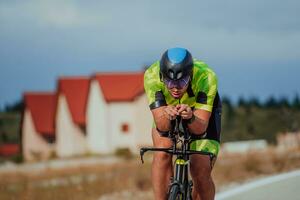 dichtbij omhoog foto van een actief triatleet in sportkleding en met een beschermend helm rijden een fiets. selectief focus