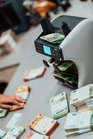 bank medewerkers gebruik makend van geld tellen machine terwijl sorteren en tellen papier bankbiljetten binnen bank kluis. groot bedragen van geld in de bank foto
