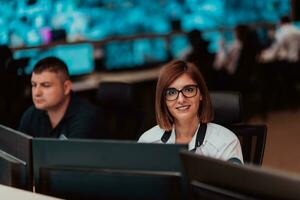 vrouw veiligheid operator werken in een gegevens systeem controle kamer kantoren technisch operator werken Bij werkstation met meerdere toont, veiligheid bewaker werken Aan meerdere monitoren foto