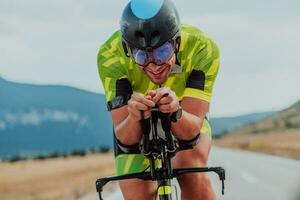 dichtbij omhoog foto van een actief triatleet in sportkleding en met een beschermend helm rijden een fiets. selectief focus
