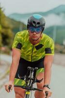 vol lengte portret van een actief triatleet in sportkleding en met een beschermend helm rijden een fiets. selectief focus foto