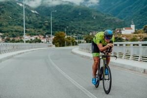 vol lengte portret van een actief triatleet in sportkleding en met een beschermend helm rijden een fiets. selectief focus foto