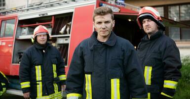 groep van brand strijders staand zelfverzekerd na een goed gedaan redden operatie. brandweer klaar voor noodgeval onderhoud. foto