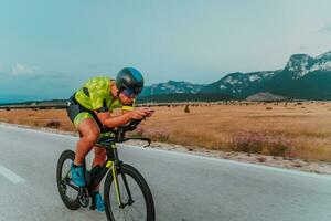 vol lengte portret van een actief triatleet in sportkleding en met een beschermend helm rijden een fiets. selectief focus foto