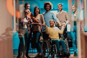 zakenvrouw in een rolstoel Aan breken in een modern kantoor met haar team in de achtergrond foto