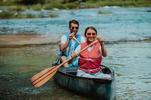 paar avontuurlijk ontdekkingsreiziger vrienden zijn kanoën in een wild rivier- omringd door de mooi natuur foto