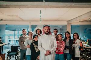 een verschillend groep van geslaagd bedrijf mensen in een modern glas kantoor staan samen Bij de top met hun Arabisch leider regisseur foto