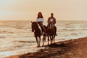 een liefhebbend paar in zomer kleren rijden een paard Aan een zanderig strand Bij zonsondergang. zee en zonsondergang in de achtergrond. selectief focus foto