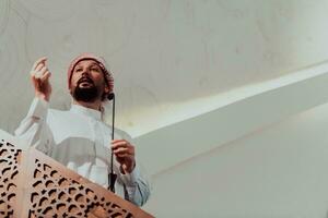 moslims Arabisch imam heeft een toespraak Aan vrijdag middag gebed in moskee. moslims hebben verzameld voor de vrijdag middag gebed in moskee en zijn luisteren naar de toespraak van imam foto