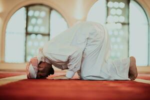 een moslim bidden in een modern moskee gedurende de heilig moslim maand van Ramadan foto
