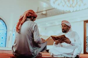 een groep van moslims lezing de heilig boek van de koran in een modern moskee gedurende de moslim vakantie van Ramadan foto