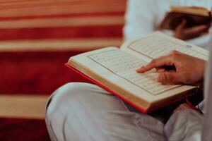 een groep van moslims lezing de heilig boek van de koran in een modern moskee gedurende de moslim vakantie van Ramadan foto