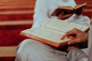 een groep van moslims lezing de heilig boek van de koran in een modern moskee gedurende de moslim vakantie van Ramadan foto