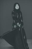zwart wit foto van mooi moslim vrouw in modieus jurk met hijab