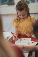 creatief kinderen zittend in een peuter- instelling, trek en hebben pret terwijl ze krijgen een onderwijs foto