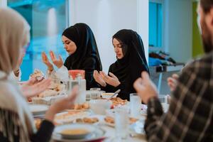 een moslim familie bidden samen, de moslim gebed na breken de snel in de Islamitisch heilig maand van Ramadan foto