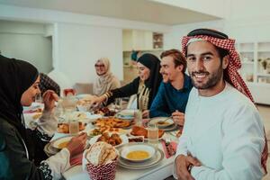 moslim familie hebben iftar avondeten drinken water naar breken feest. aan het eten traditioneel voedsel gedurende Ramadan feesten maand Bij huis. de Islamitisch halal aan het eten en drinken in modern huis foto